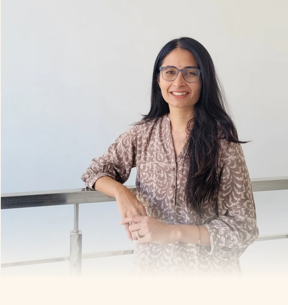 Harini standing on a balcony in the morning light