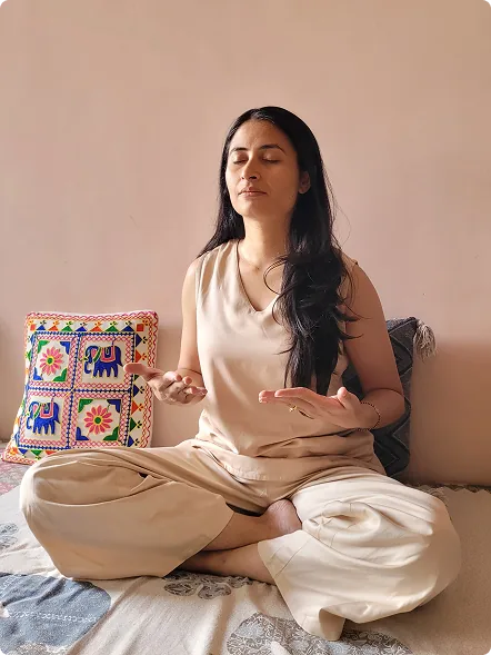 Harini in Sukhasana, seated in meditation with her hands resting open on her knees