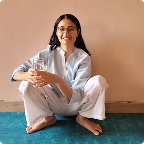 Harini seated with a glass of water, part of a mindful daily routine