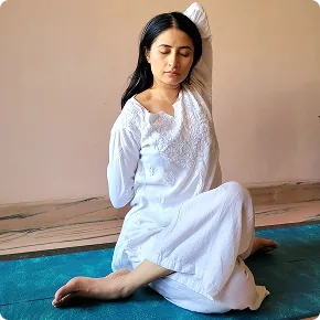 Harini seated with her head tilted back in a gentle neck release